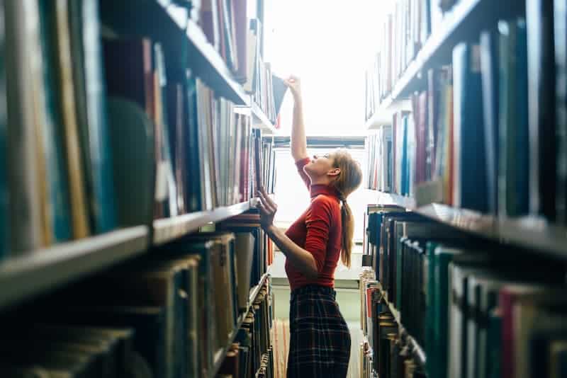 Eine Frau in einer Bibliothek, was ist eine gute Literaturrecherche?