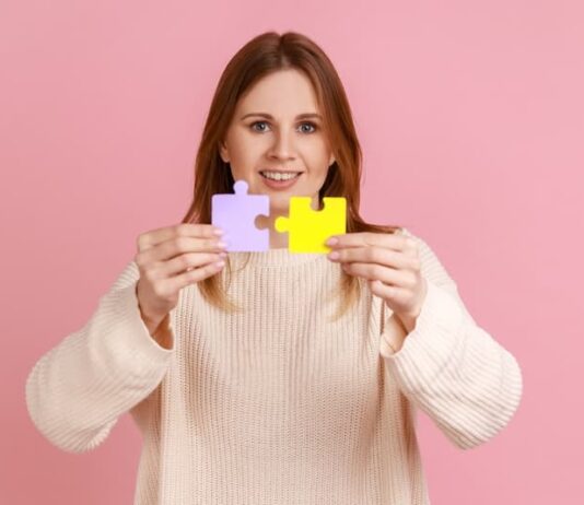 Eine Frau mit zwei Puzzleteilen, welche Bedeutung hat die Problemlösung im Job?