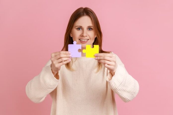Eine Frau mit zwei Puzzleteilen, welche Bedeutung hat die Problemlösung im Job?