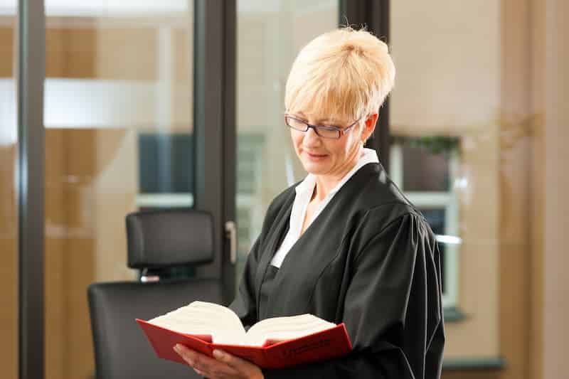 Eine Anwältin blättert im Buch, was steht im Arbeitsschutzgesetz?