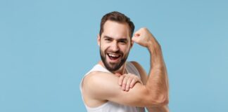 Ein Mann zeigt seine Armmuskeln, wie lässt sich das Selbstbewusstsein stärken?