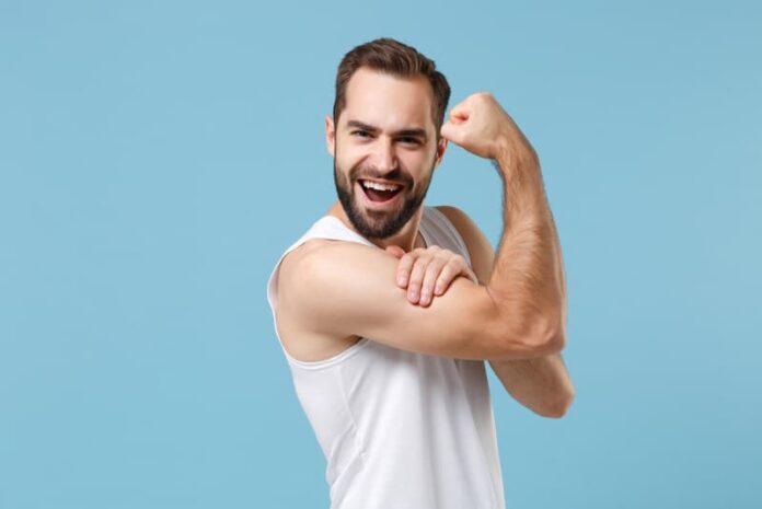 Ein Mann zeigt seine Armmuskeln, wie lässt sich das Selbstbewusstsein stärken?
