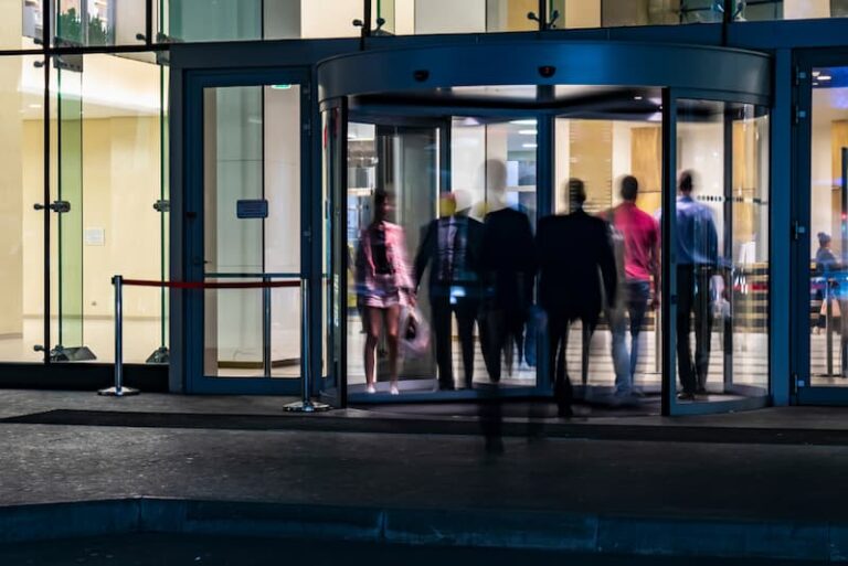 Menschen gehen durch eine Drehtür, was zeigt eine hohe Fluktuation im Unternehmen?
