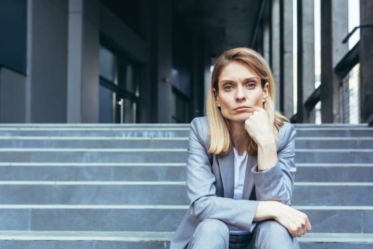Eine Frau sitzt auf der Treppe, sie ist in der Teilzeitfalle