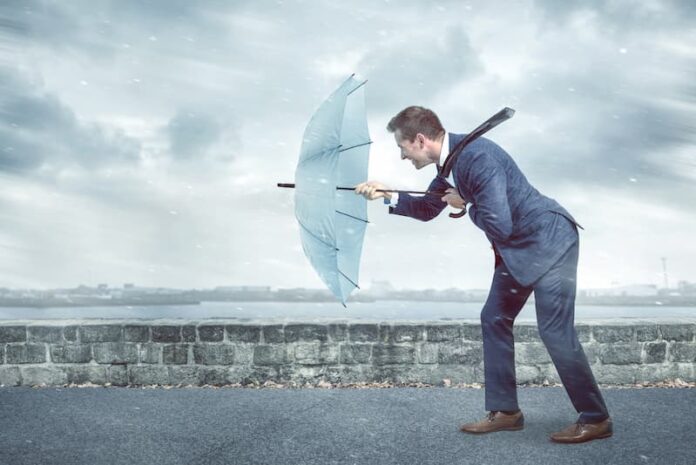 Ein Mann hält einen Regenschirm gegen den Wind, was ist Resilienz?