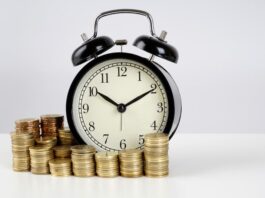 Eine Uhr und Münzen, was ist der Zeitlohn?