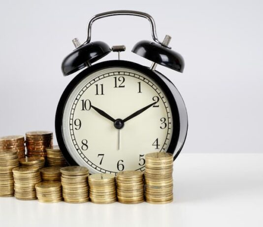 Eine Uhr und Münzen, was ist der Zeitlohn?