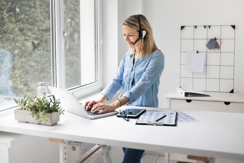 Eine Frau arbeitet im Stehen, was dient der Gesundheit am Arbeitsplatz?