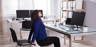 Eine Frau macht eine Übung mit einem Stuhl, welche Möglichkeiten gibt es bei der Bewegung am Arbeitsplatz?