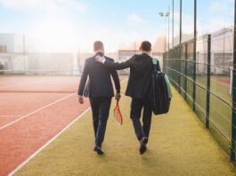 Zwei Männer im Anzug mit Tennisschlägern, was ist Sport nach der Arbeit?