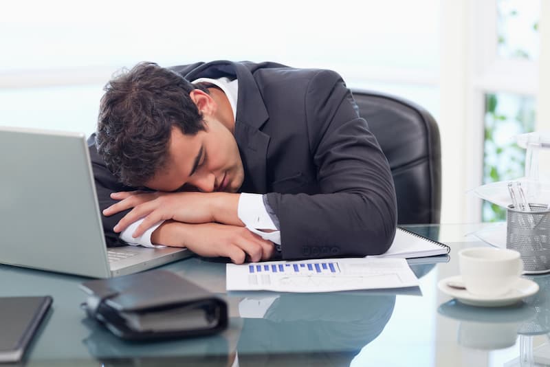 Ein Mann schläft auf dem Tisch, was ist Powernapping?