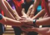 Mehrere Sportler halten die Hände zusammen, was ist Teamfähigkeit?