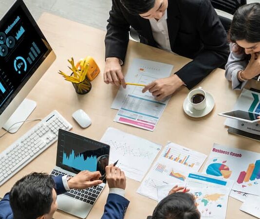 Mehrere Menschen sitzen an einem Arbeitstisch, was ist Visualisierung?