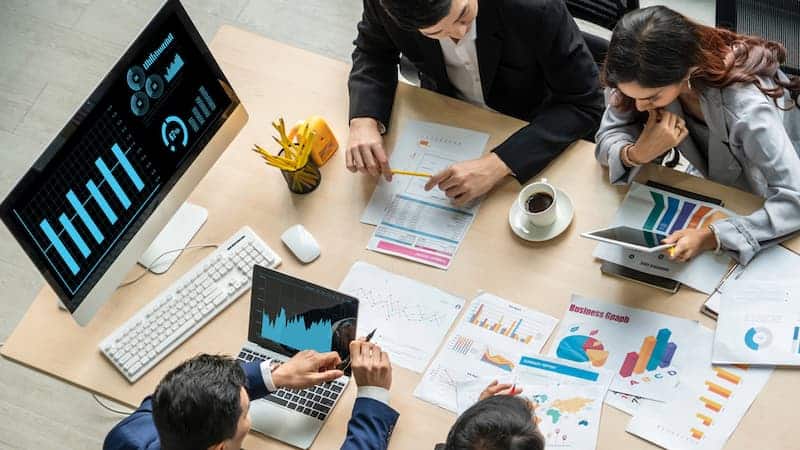 Mehrere Menschen sitzen an einem Arbeitstisch, was ist Visualisierung?