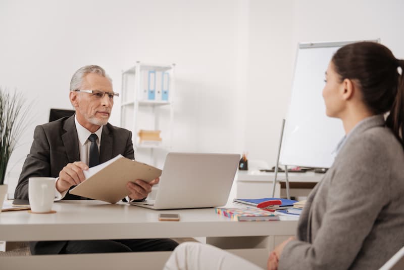 Eine Frau im Gespräch mit dem Arbeitgeber, sie möchte vor Arbeitsantritt kündigen