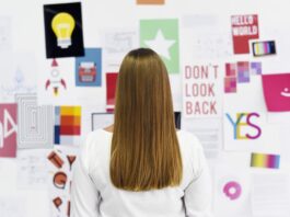 Eine Frau steht vor einem Vision Board