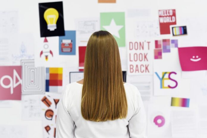 Eine Frau steht vor einem Vision Board