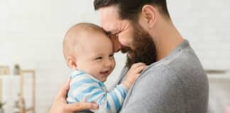 Ein Vater kuschelt im Vaterschaftsurlaub mit seinem Kind
