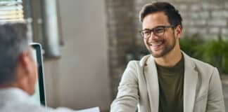 Ein Bewerberschüttelt nach einem erfolgreichen Vorstellungsgespräch die Hand des Interviewers. Er hat einen guten Eindruck gemacht und gegebenenfalls von Halo-Effekt profitiert.