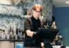 Ein Schüler steht im Bistro hinter der Kasse. Er übt einen Schülerjob aus.