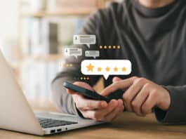 Ein Angestellter gibt seinem Arbeitgeber mit seinem Smartphone online eine gute öffentliche Bewertung. Das ist das Ergebnis von gutem Reputationsmanagement in Unternehmen.