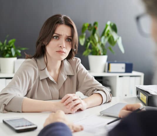 Eine Bewerberin schau skeptisch. Sie möchte das Vorstellungsgespräch abbrechen.