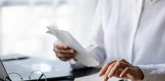 Grundgehalt vs. Bonus: Das ist der Unterschied Eine Person tippt auf dem Taschenrechner. Sie berechnet Grundgehalt und Bonus.