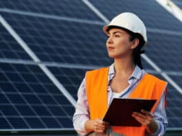 Ingenieurin steht mit Notizbrett vor Solarpanels. Ein Beispiel für Berufe mit Zukunft für Frauen.